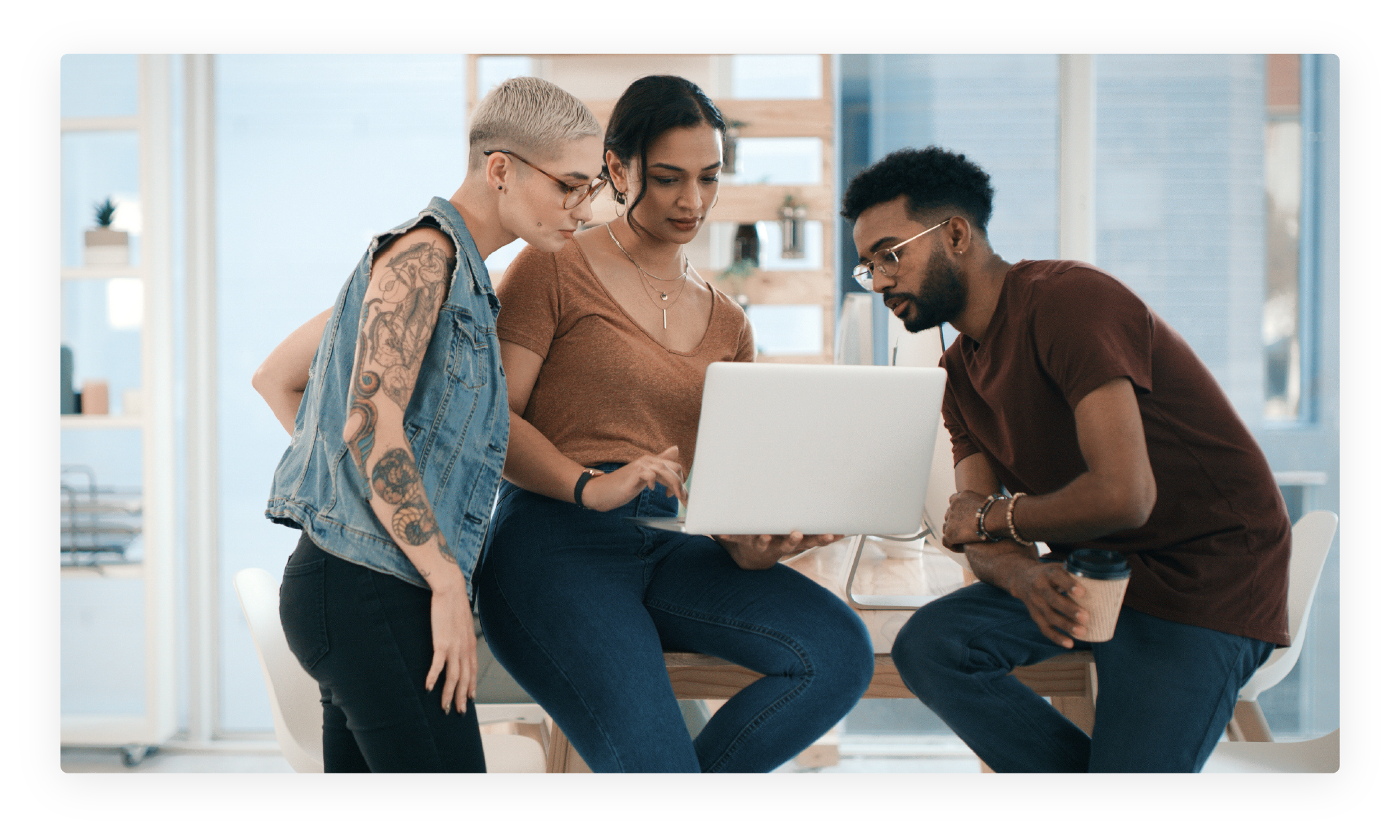 Three employees looking at a computer together